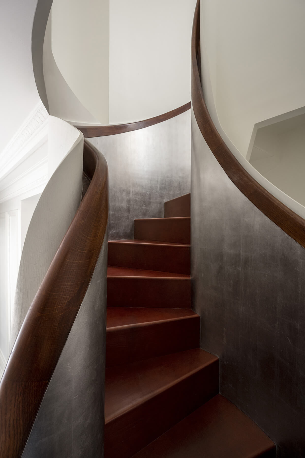 Escalier courbe en chêne, cuir et palladium de la résidence Giraudoux